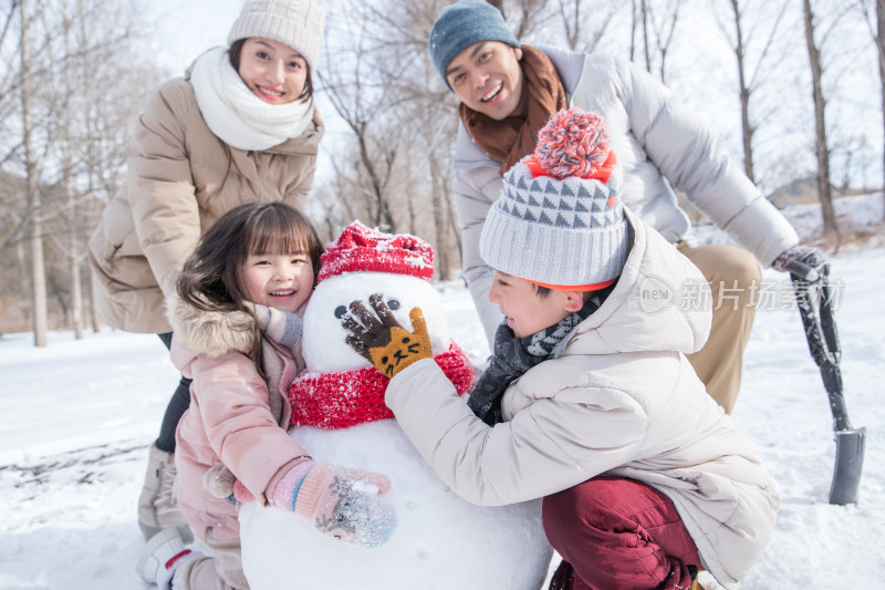 欢乐家庭在雪地里堆雪人