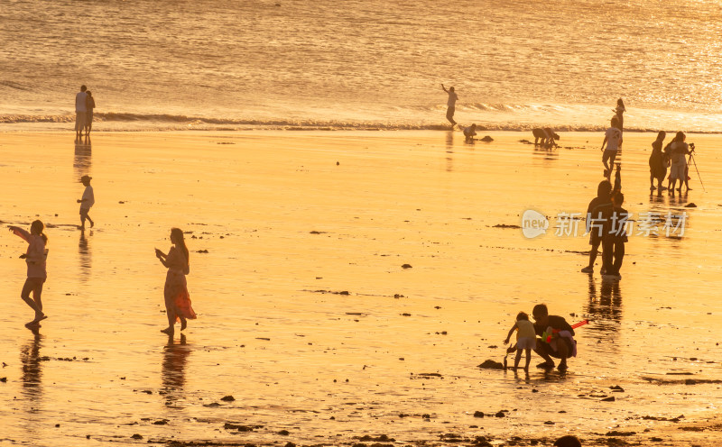 海边夕阳下的人群休闲场景