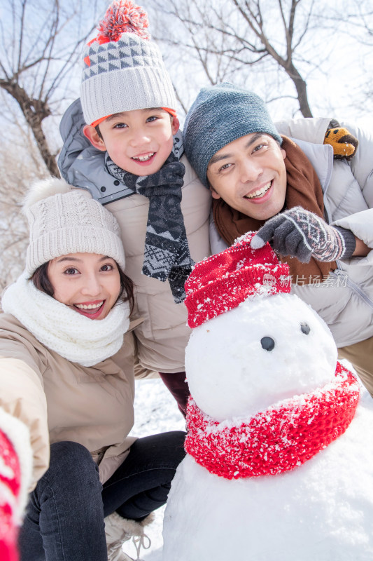 一家三口在雪地里堆雪人