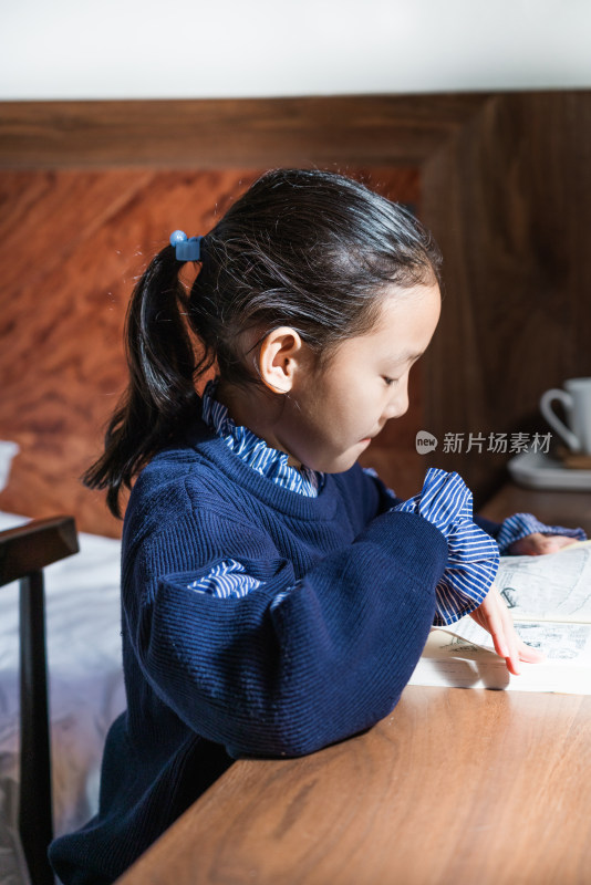 坐在房间内认真看书的中国女孩