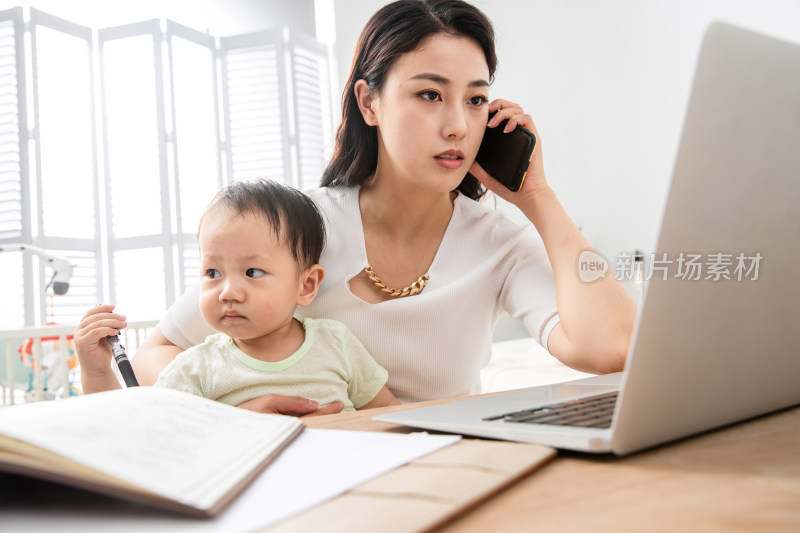 年轻妈妈带着宝宝看电脑