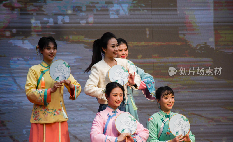 女子身着传统服饰持扇表演