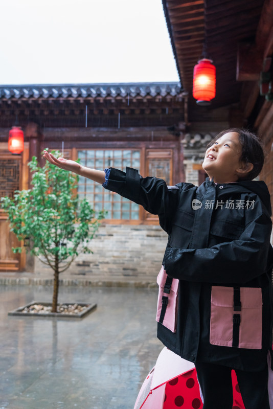 下雨天在中式四合院里玩耍的中国女孩