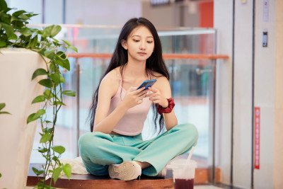 假日在商场休息区用手机自拍的中国少女