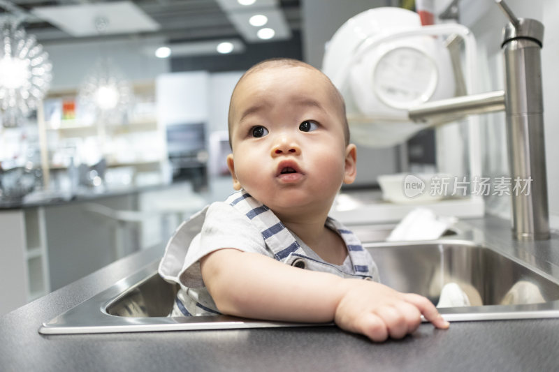 男宝宝坐在厨房的水池里