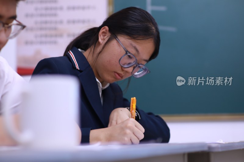 穿校服的女生在教室中用笔写字 学习