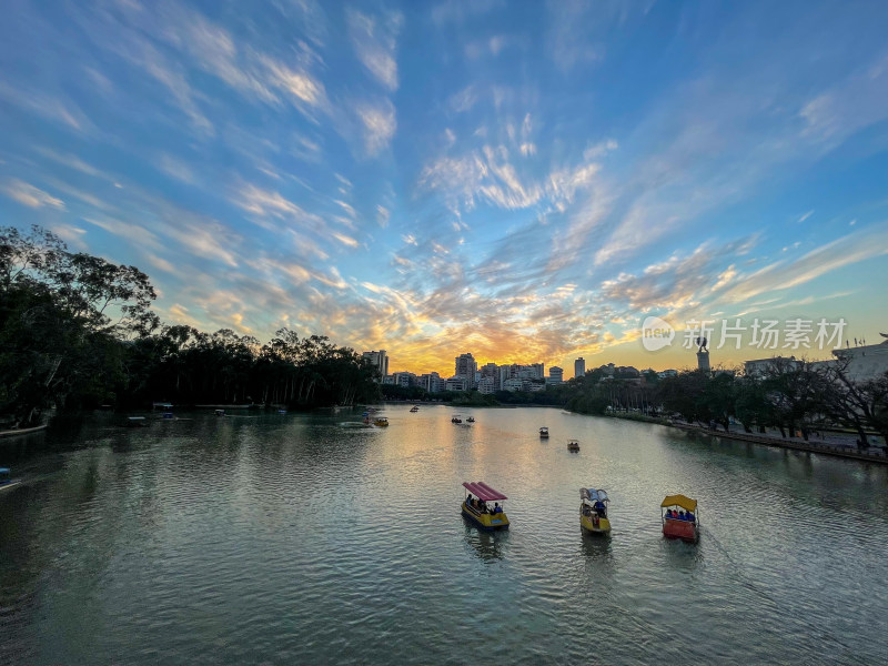 日落时分水面游船与城市建筑景观