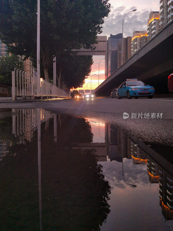 城市道路积水倒影的傍晚街景