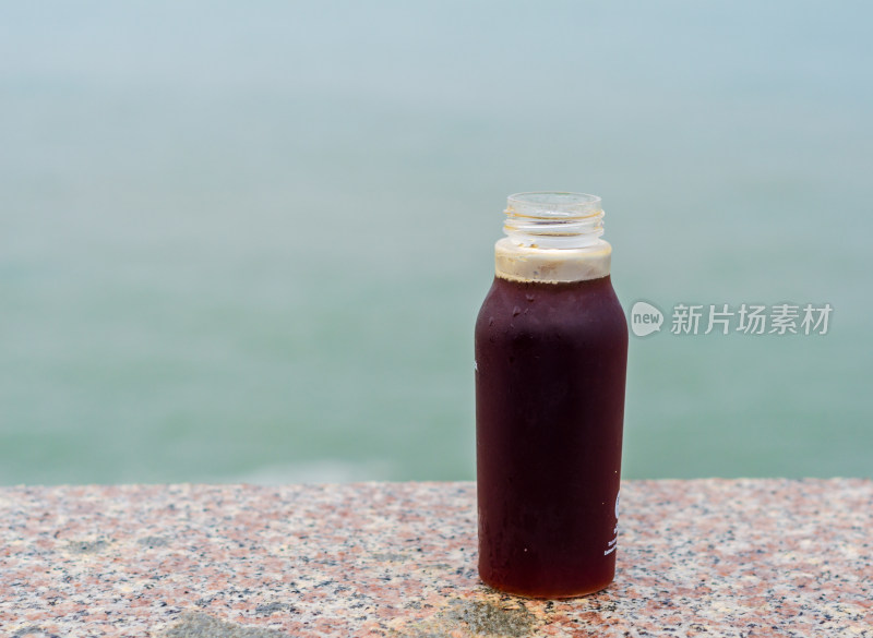 海边石桌上的一瓶酸梅汤