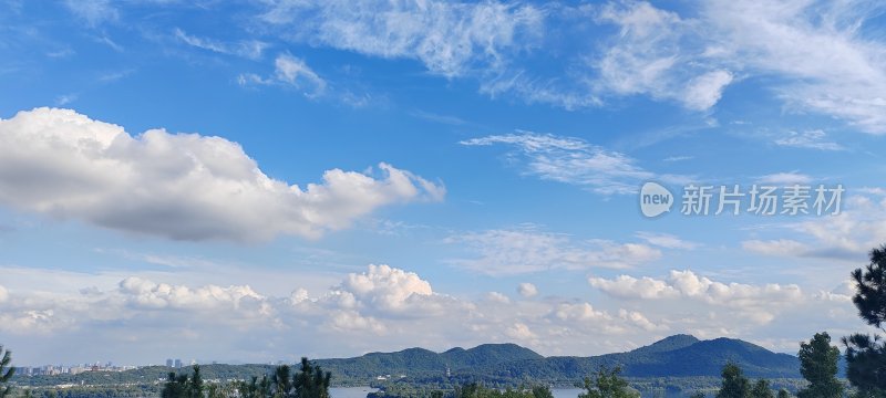 蓝天白云下的山峦与城市远景