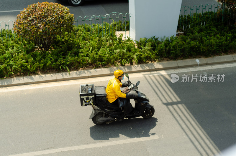 马路上骑车的美团外卖送餐员