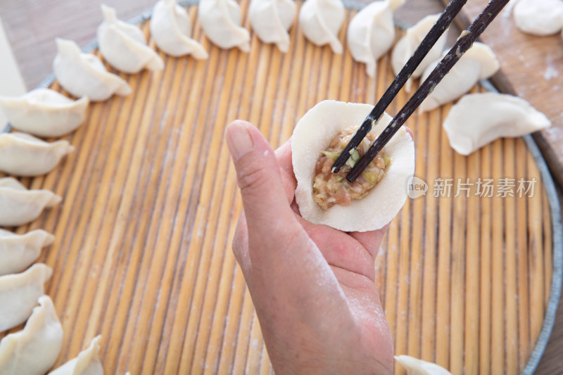 中国人正在包肉馅白面饺子