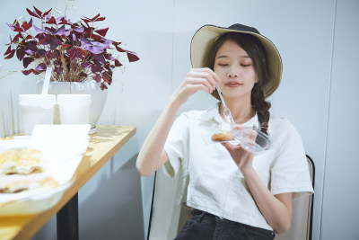 在烘焙店吃面包喝牛奶的可爱亚洲少女