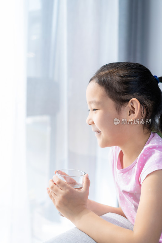 坐在沙发上喝水休息的中国女孩