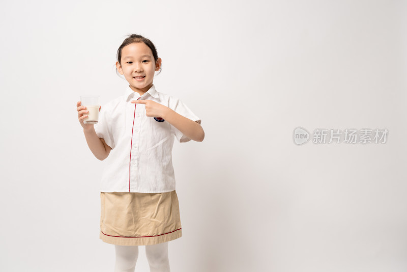 站在白色背景前穿校服喝牛奶的中国女孩