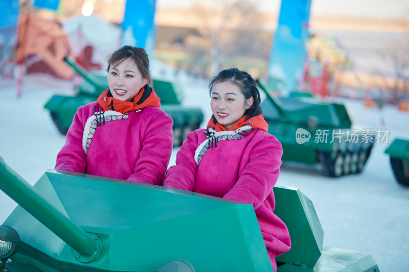 在冰天雪地玩耍雪上娱乐载具车辆的闺蜜少女