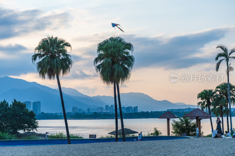 湖畔沙滩放风筝的休闲场景