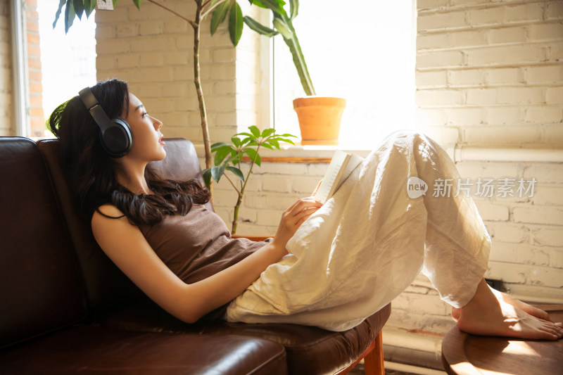 年轻女人在家听音乐看书