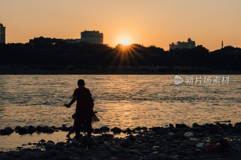 夕阳时在澜沧江边玩水人的剪影