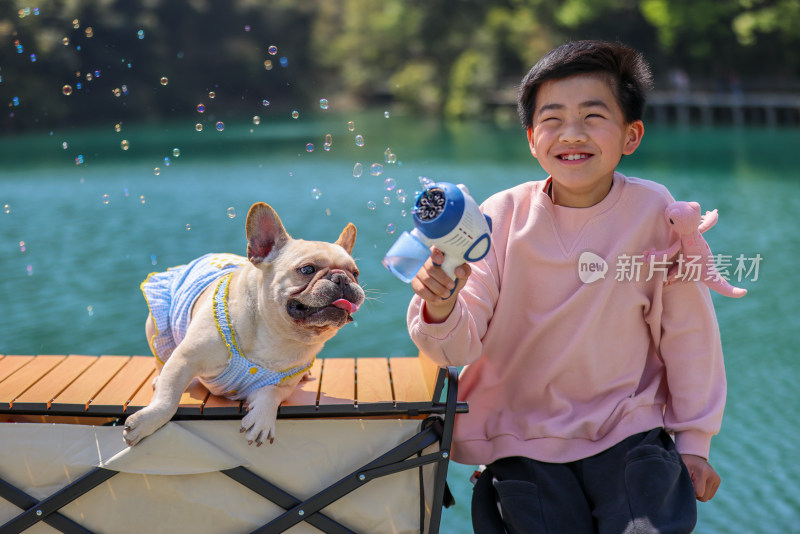 可爱的小男孩和他的狗在湖边露营