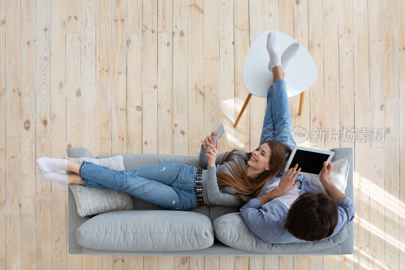 情侣沙发上休闲使用电子设备