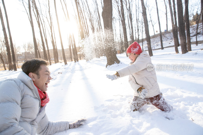 在雪地上玩耍的快乐父子