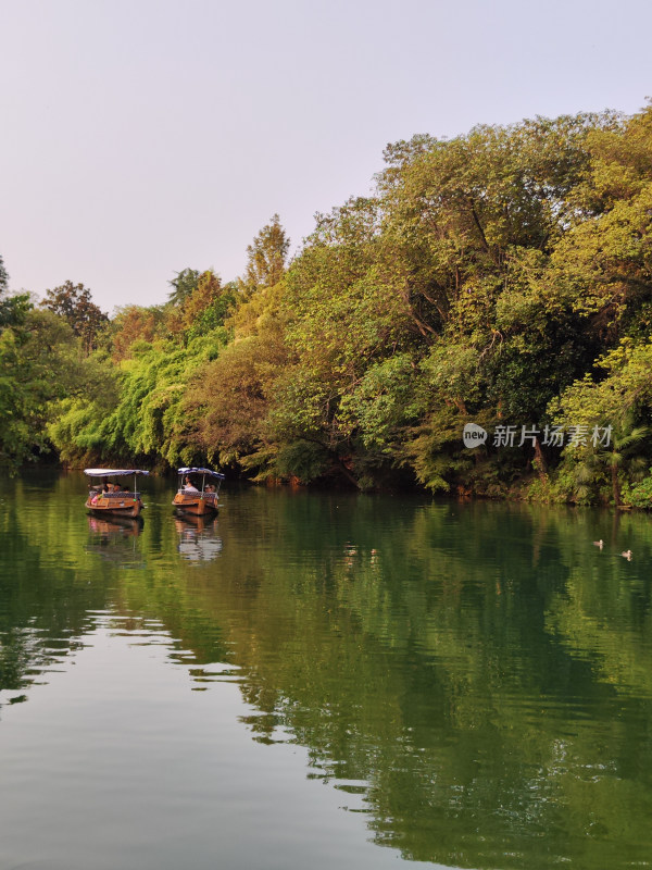 浴鹄湾河上船只与岸边树林景观