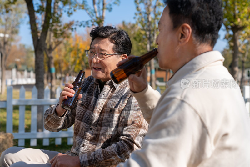 两个老年男人坐在露营地喝啤酒