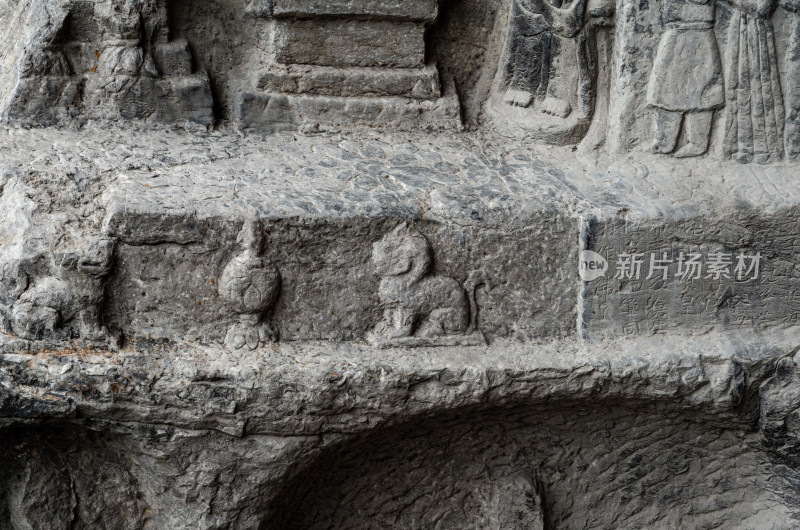 河南洛阳龙门石窟的石壁上的小佛像和神兽