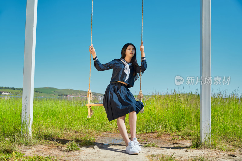 草原湖畔打卡点游玩拍照的亚洲少女