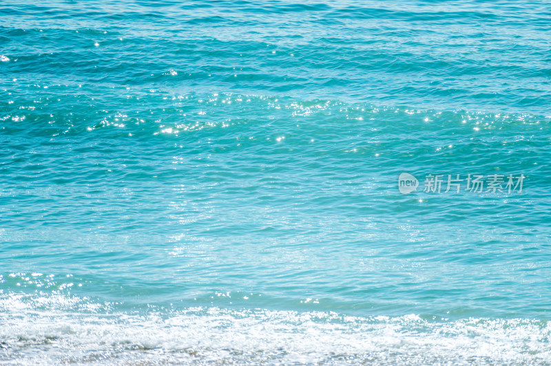 海南三亚阳光下绿松石海浪浪花冲浪