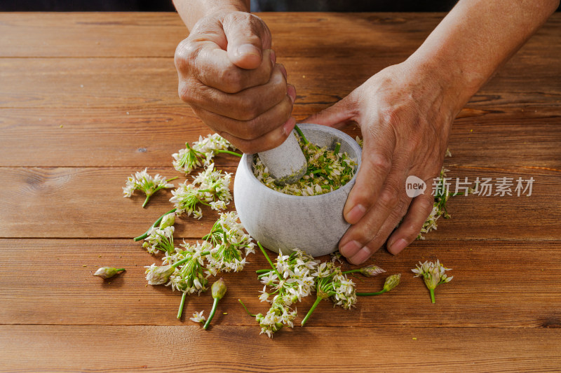 木质背景下的石臼和韭菜花