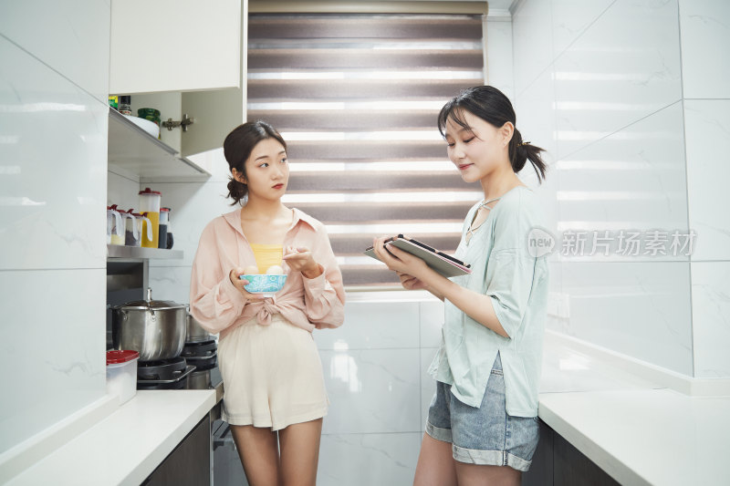 在厨房烹饪美食的亚洲闺蜜少女