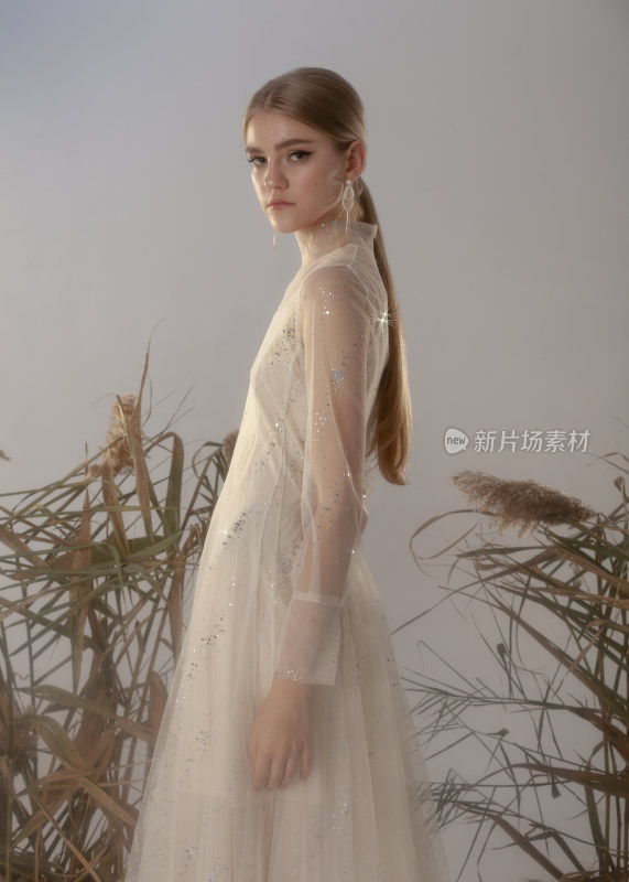 金发女子身着纱裙侧立摆拍