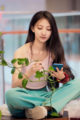 假日在商场休息区用手机自拍的中国少女