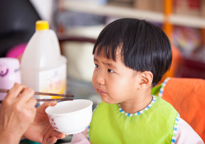 正在给亚洲面孔的小女孩喂饭