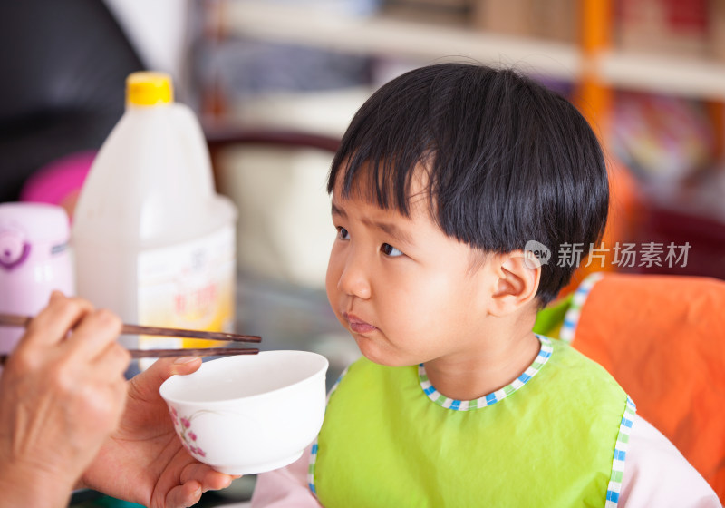 正在给亚洲面孔的小女孩喂饭