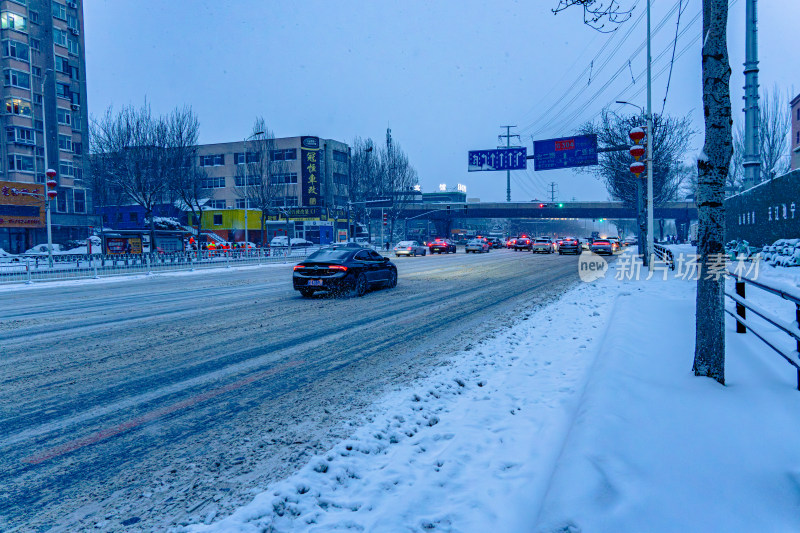 雪天夜晚亮灯的居民楼外景马路街道