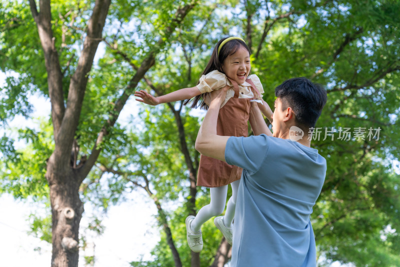 爸爸抱起女儿张开双臂转圈旋转