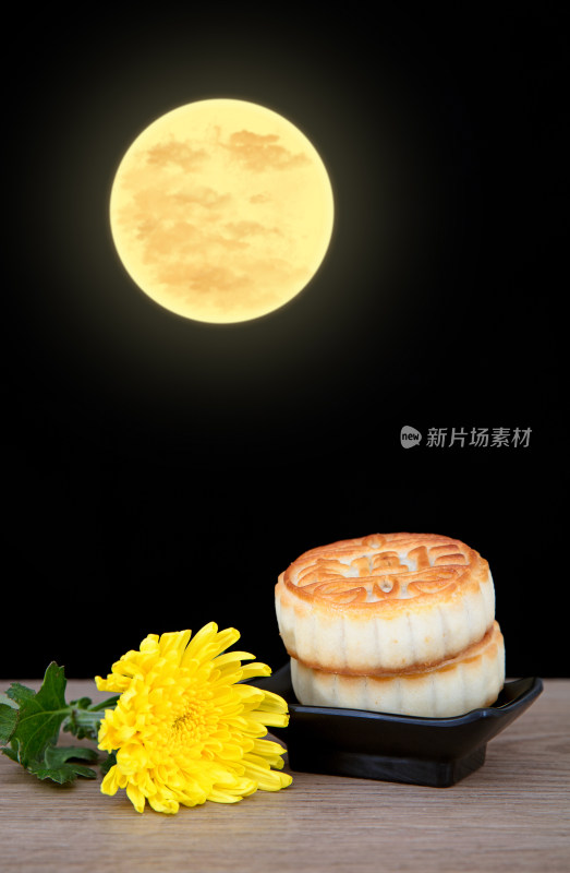 桌子上中秋节的月饼和一朵黄菊花