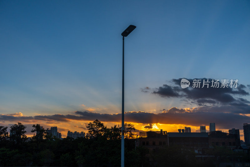 夕阳下城市中矗立着的路灯