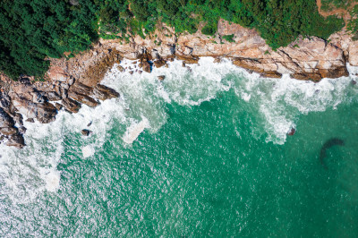 航拍海边岩石与碧绿海水相映的景观