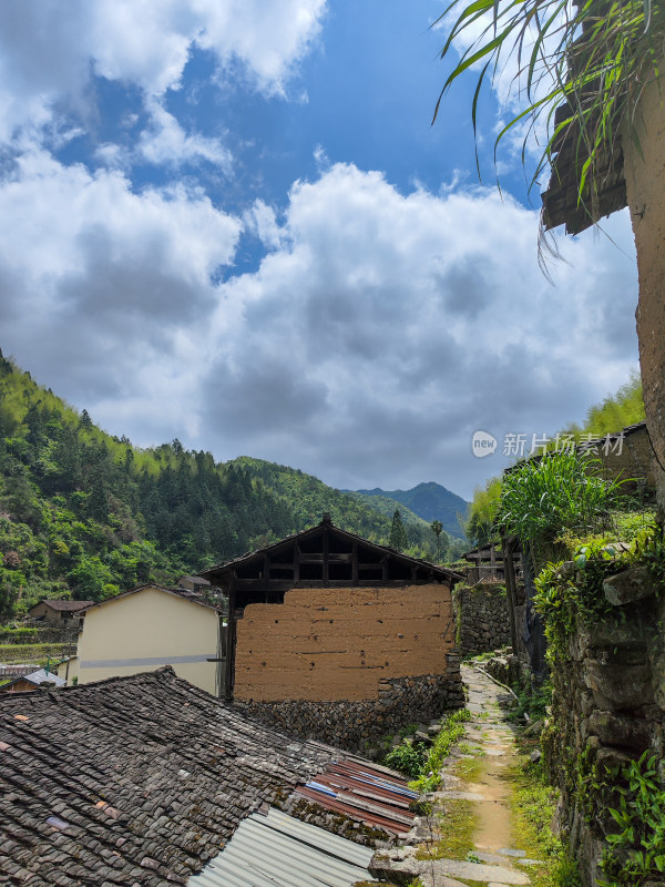 乡村房屋小径景致，周边山林环绕