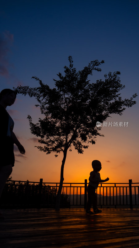夕阳黄昏晚霞小孩儿童婴儿学走路剪影树旁