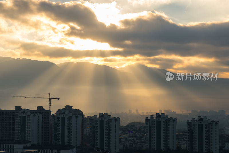 城市建筑群中阳光穿透云层的景象