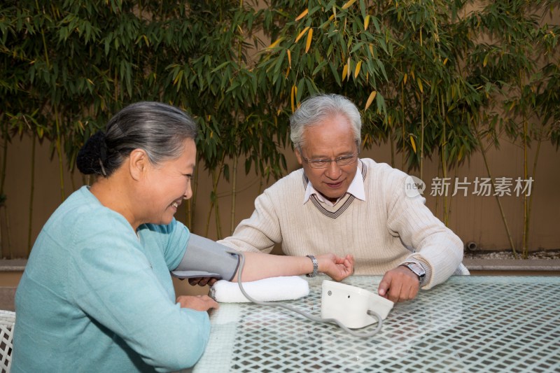 老年夫妻在院子里量血压