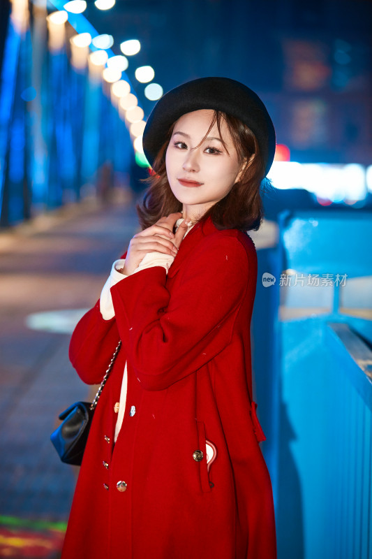 夜晚在繁华灯火的街头拍照的亚洲少女