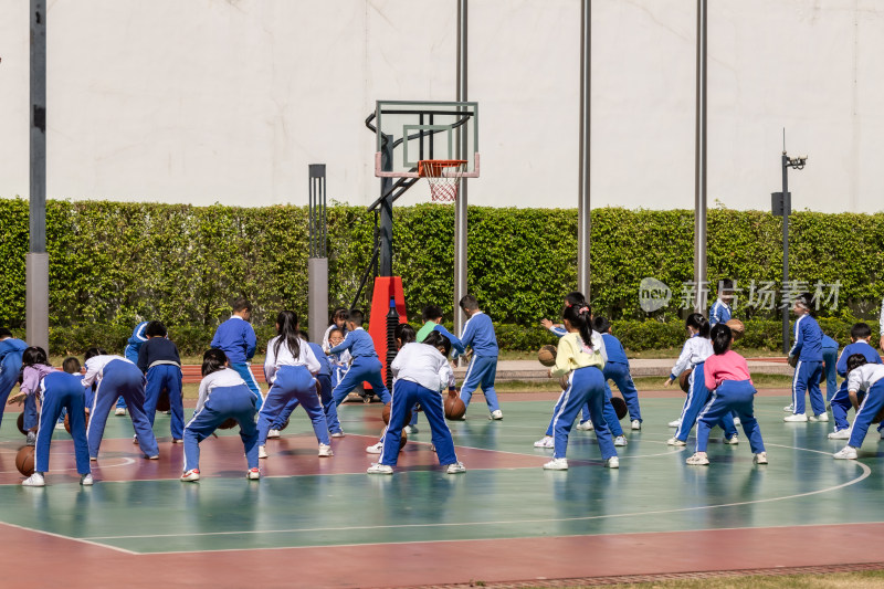 小学生在操场进行篮球训练