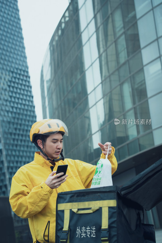 送餐的青年外卖员查看手机订单