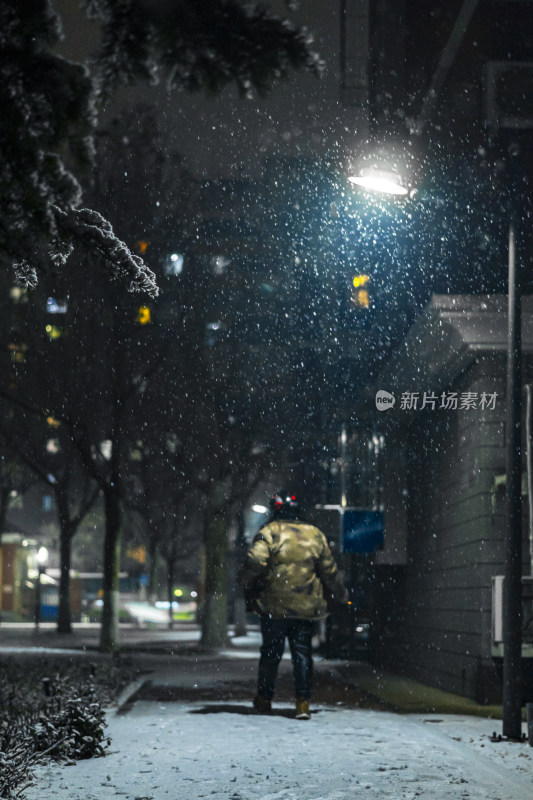 夜晚雪中行人背影